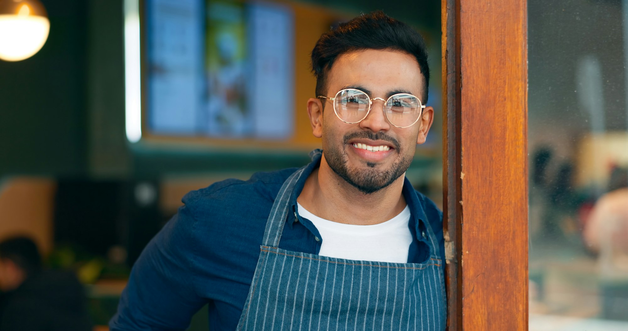 Portrait, entrance and happy man, restaurant business owner or coffee shop manager smile for cafete